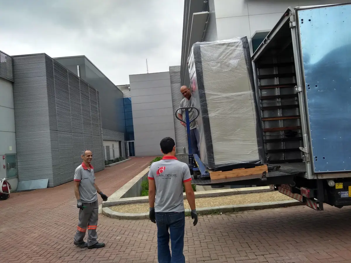 Equipe da Cpandalog posicionando um equipamento embalado na plataforma do caminhão